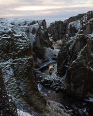 A deep and winding snow covered river canyon lit by the rising sun. Fjadrargljufur, Iceland...