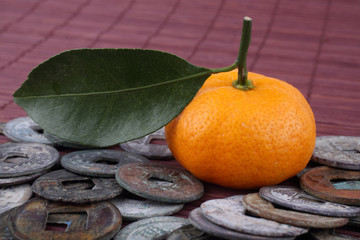 Mandarin oranges and ancient Chinese coins on bamboo background. Symbols of luck and Chinese New...