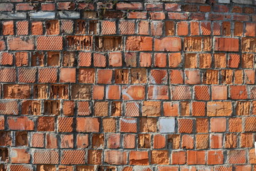 Old chipped wall of large red brick