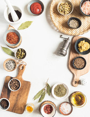 Frame of various dry spices and sauces on a light background. Flat lay of small bowls with dijon mustard, olive oil, ketchup, capers and spices.