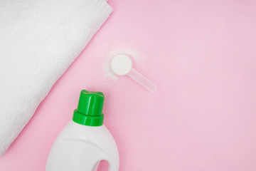 Towel, washing powder and plastic botte on pink background top view.