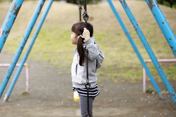 ブランコで立ちこぎをする幼児(5歳児)