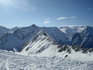 Beach huts lined up in front of the beach with a clear blue sky on a summers day.