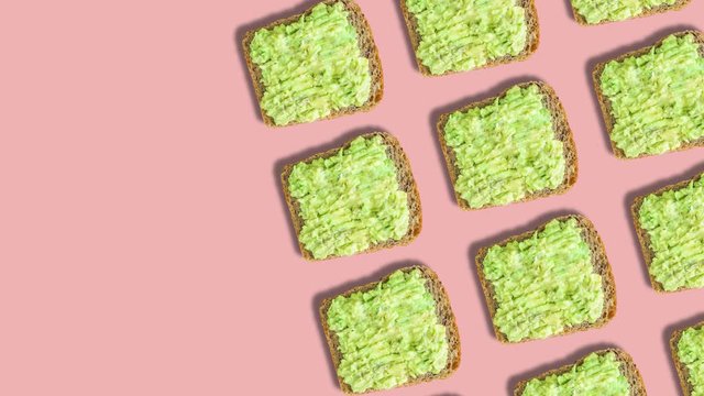 Vertical pattern with avocado toast. Creative background for cell phone. Powder pink background, top view. Healthy food concept, vegan