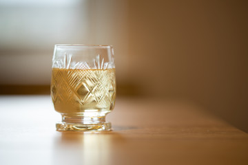 Small crystal glass with pale-yellow drink
