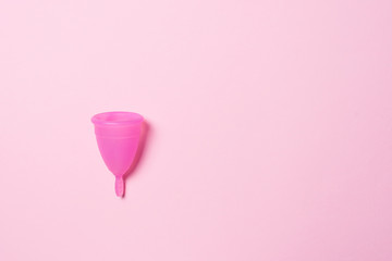 Copa menstrual de silicona. Salud de la mujer e higiene alternativa. Fondo rosa