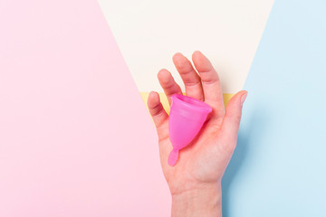 Copa menstrual de silicona sobre la mano de una mujer. Salud de la mujer e higiene alternativa....