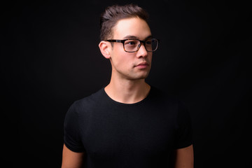 Obraz premium Young handsome multi ethnic man against black background