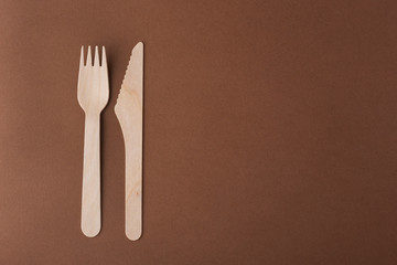 disposable Cutlery made of eco material, on a brown background, top view, eco waste