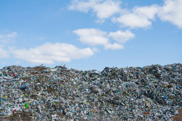 The mountain of plastic waste from urban communities and industrial districts and the blue sky
