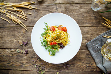 Italian spaghetti pasta with olives and tomatoes