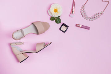 Composition with women's sandals and accessories on pink background.