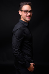 Fototapeta premium Young handsome multi ethnic businessman against black background