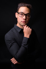 Obraz premium Young handsome multi ethnic businessman against black background
