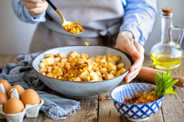 A cook is preparing a filling for apple strudel. Girl chooses a suit in a bowl with apple filling for strudel. Falling asleep raisins in the desert. Vegetarian food. Cooking apple and raisin pie
