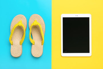 Swimming accessories - trendy summer flip flop, tablet with black screen on blue, yellow background Flat lay Top view Travel, vacation, online booking concept Mock up