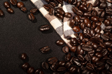 Coffee beans on brown linen fabric background.Roasted coffee beans texture, used as a background.Flat lay, top view, copy space.