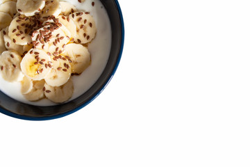 Yogurt with bananas, flax seeds and honey isolated on white background with copy space