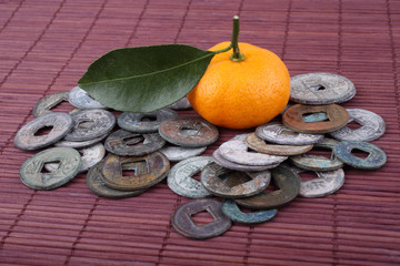 Mandarin oranges and ancient Chinese coins on bamboo background. Symbols of luck and Chinese New...