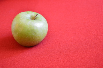 green apple on red background