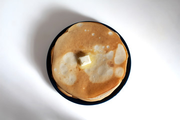 Homemade pancakes with butter on a white table