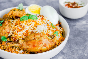 Chicken Biryani with Raita and Eggs on Dark Background Extreme Close Up Photo

