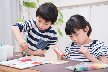 絵の具で作品に色を塗る小学生