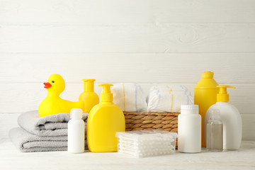 Baby hygiene accessories on white wooden background