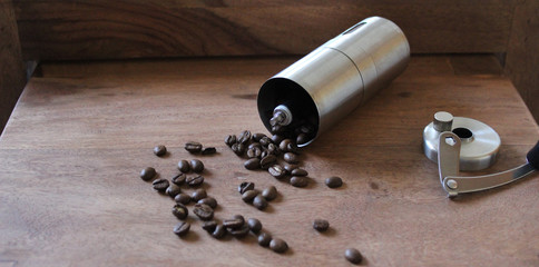 Eine umgekippte, moderne Kaffeemühle mit Kaffeebohnen