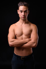 Fototapeta premium Young handsome multi ethnic man shirtless against black background
