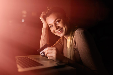 Satisfied woman buying online looking at camera sitting near lap