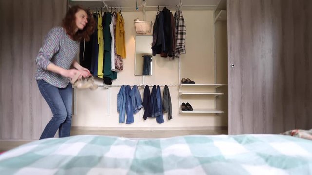 time lapse of woman putting clothes in wardrobe