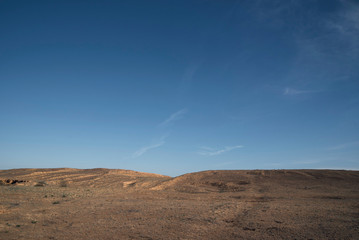 Fototapeta na wymiar A hill in the steppe under a blue sky