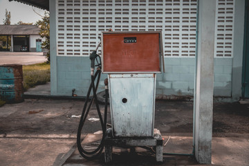 aged and worn vintage photo of old gas station with pumps