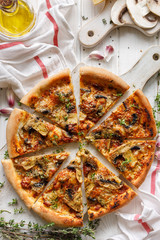 Mushroom pizza with the addition of parmesan cheese and herbs divided into parts on a white board, top view