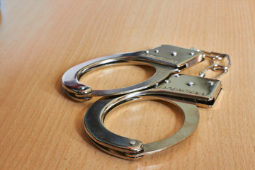 police handcuffs on wooden table