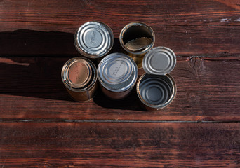 old empty cans on a wooden table, brown wooden background