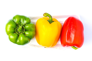 Top view colorful vegetable, yellow, green and red, bell pepper on foam tray isolated on white background