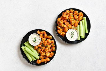 Cauliflower buffalo wings with celery and sauce