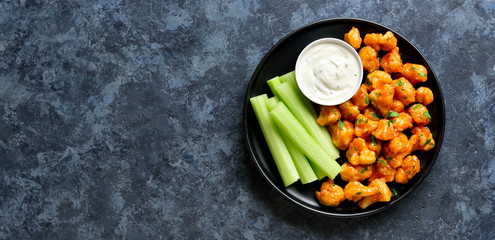 Cauliflower buffalo wings with celery and sauce