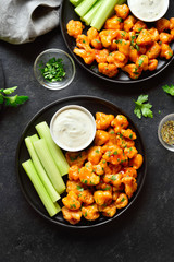 Cauliflower buffalo wings with celery and sauce