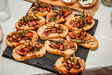 sandwiches with roast beef meat on a black plate