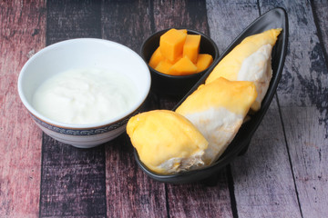 Natural  yogurt serve with the popular Thai fruits as ripe Chanee Durian and ripe cubed mango.