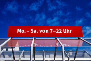 Schild mit Öffnungszeiten eines Supermarktes