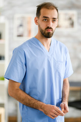 Fototapeta na wymiar Portrait of young doctor in his uniform. Nursing home.