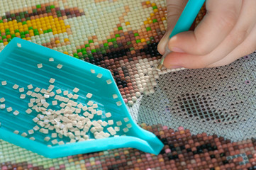 Collecting diamond embroidery, diamond mosaic. Colored crystals. Needlework. Creation.