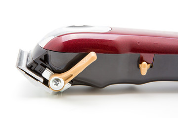 Red clippers for cutting hair on a white background