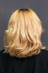Close up long hairstyle of blonde woman, back view.