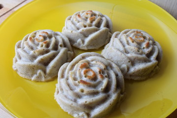 four cupcakes like roses on a yellow plate