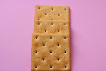 cracker in a row on a pink background